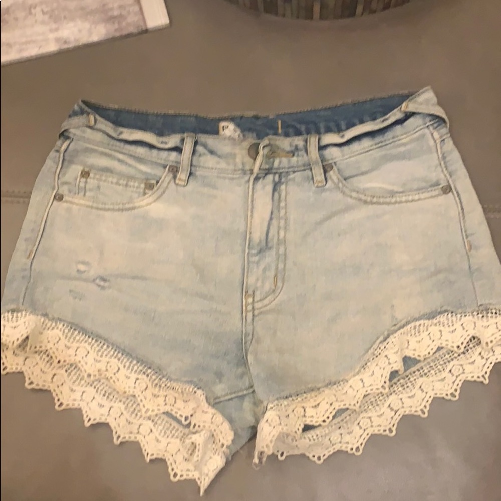 Free people jean shorts with white lace trim